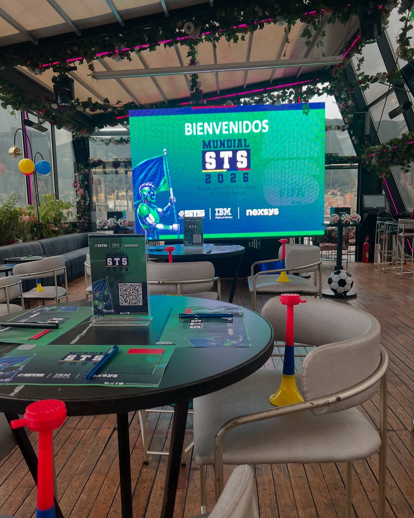 Pantalla de bienvenida de la activación Mundial STS 2026, con mesas y ambientación temática de fútbol
