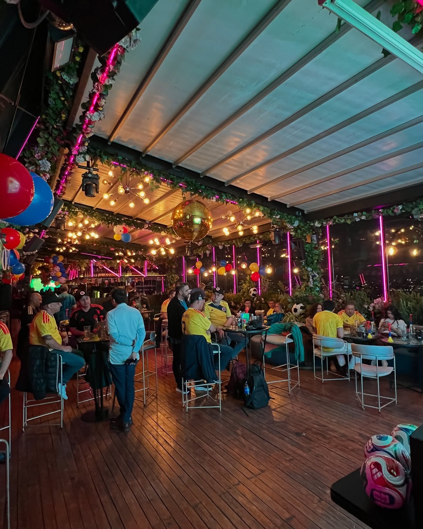 Asistentes disfrutando la activación Mundial STS 2026 en un espacio decorado con luces y balones de fútbol